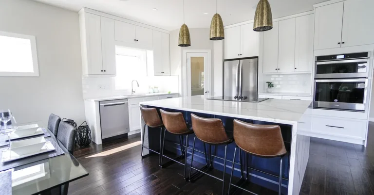 Modern kitchen with dark hardwood floors and white cabinets around a kitchen island