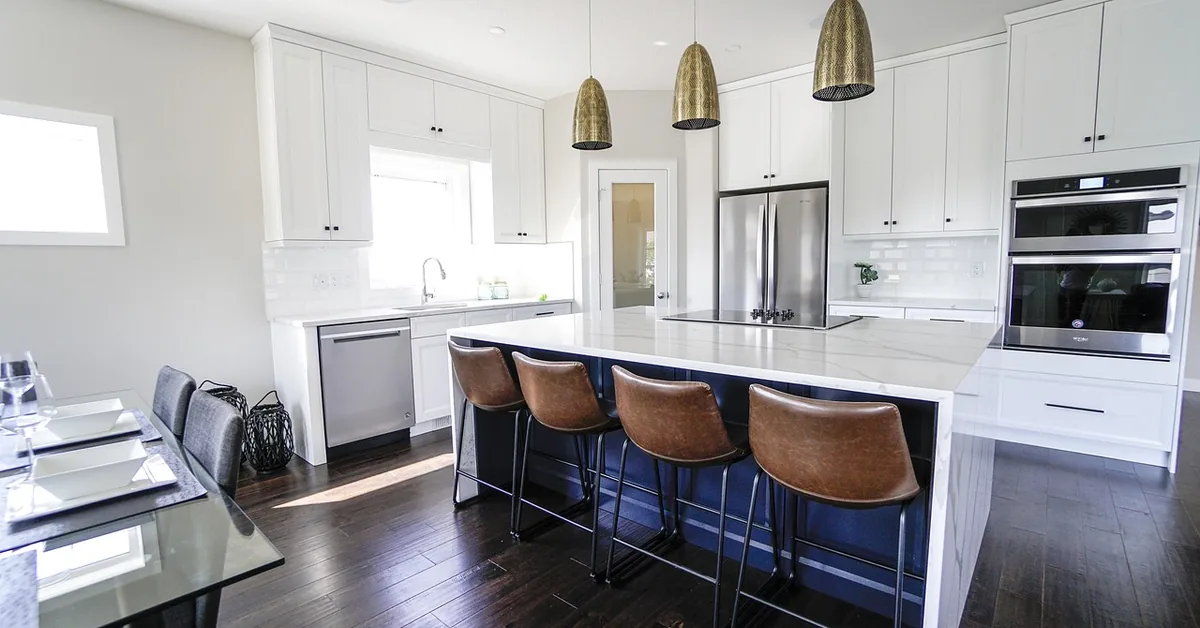 Modern kitchen with dark hardwood floors and white cabinets around a kitchen island