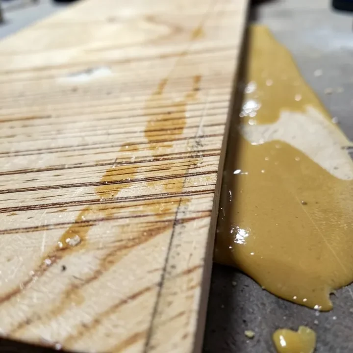 Wood board showing uneven lap marks next to a smoothly blended polyurethane stain section