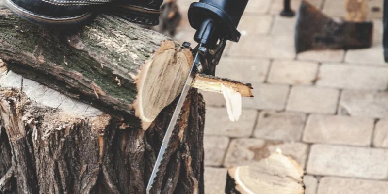 A reciprocating saw blade cutting through a wood log