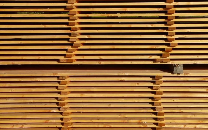 Stacked sawn lumber boards separated by spacer sticks