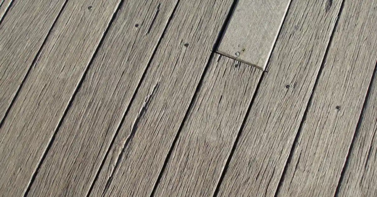 Weathered pressure-treated wood deck boards showing natural graying without stain or sealer