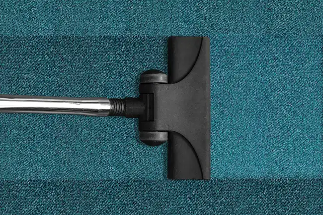 Close-up of a vacuum floor head making contact with carpet fibers Close-up of a vacuum floor head making contact with carpet fibers