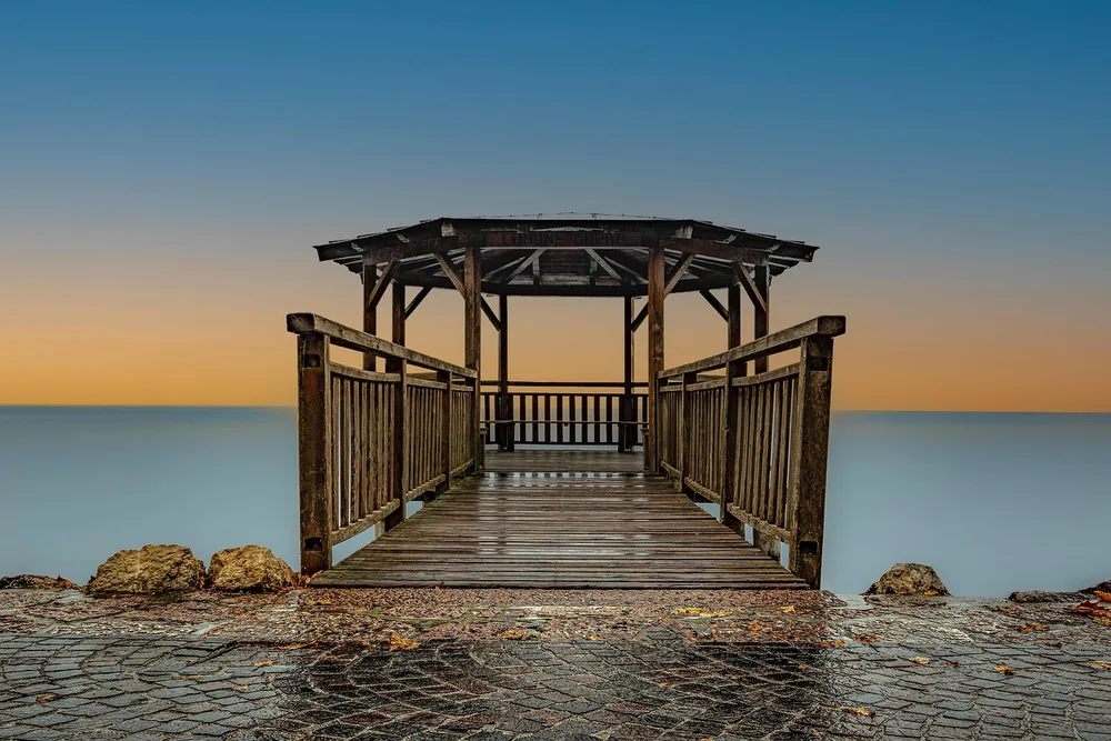 Weathered wooden dock and gazebo with wet horizontal deck boards