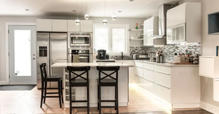 bright white kitchen cabinets with warm wood floor and pendant lighting