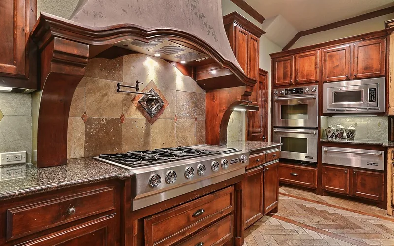 Rich reddish-brown wood kitchen cabinets showing a glossy finish