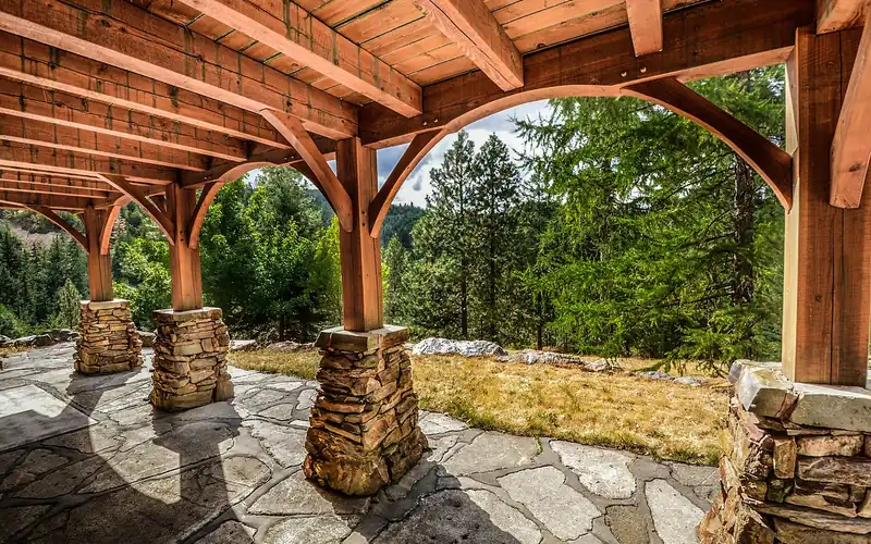 wood pergola and deck framing built over a stone patio anchored to a concrete footing wood pergola and deck framing built over a stone patio anchored to a concrete footing