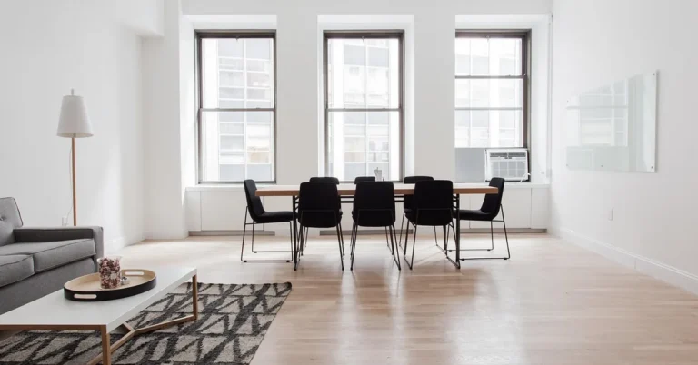 Hardwood floor in a living room protected by an area rug and furniture legs on pads