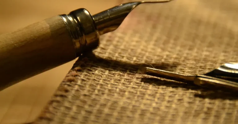 Wood engraving graver with a wooden handle resting on burlap cloth