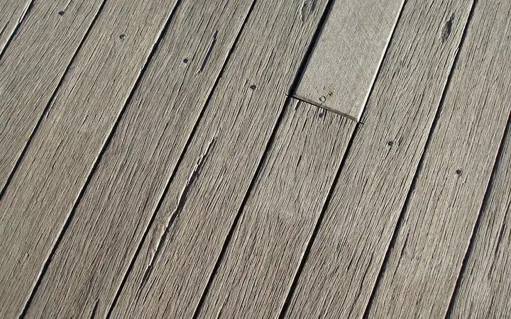 Bare weathered gray deck boards with a worn open grain