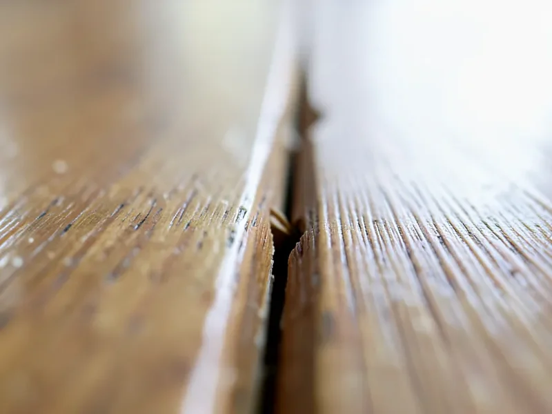 Small seasonal gap between hardwood floor boards caused by low winter humidity