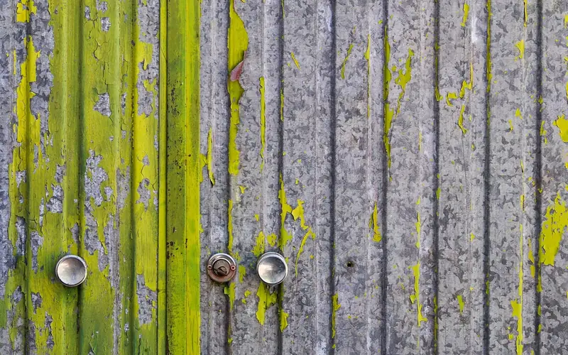old peeling paint on a wood door in a workshop before stripping old peeling paint on a wood door in a workshop before stripping