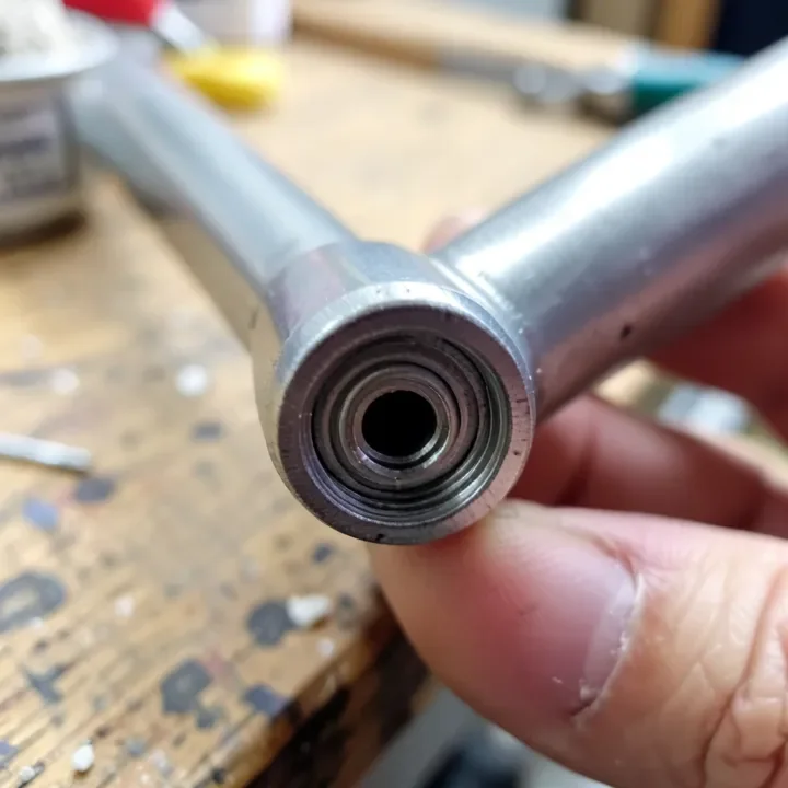 Close-up of a paint roller frame threaded metal end showing the screw threads