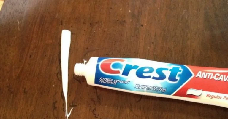 Toothpaste being used to remove a permanent marker stain from lacquered wood