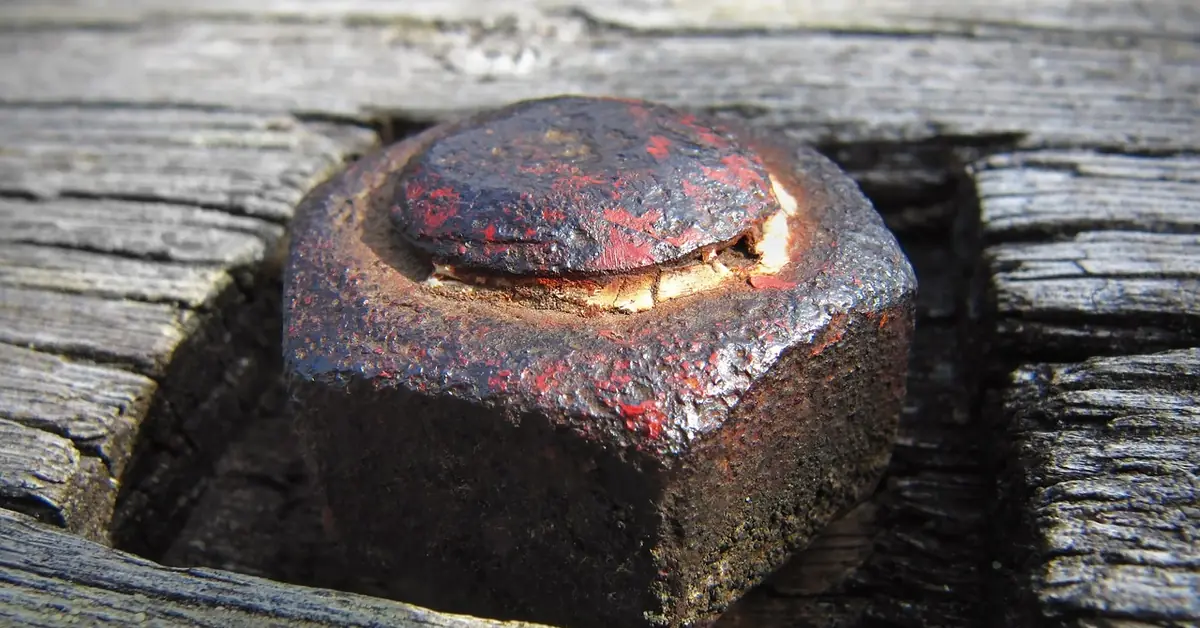 heavily rusted bolt head sitting in a decking board's screw recess