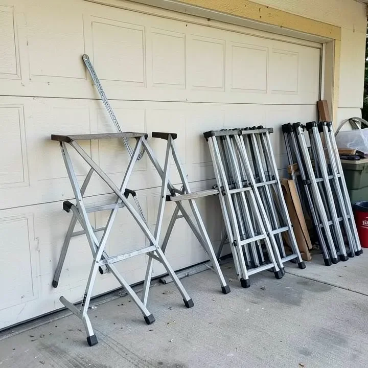 Folded sawhorses leaning against a garage wall for storage
