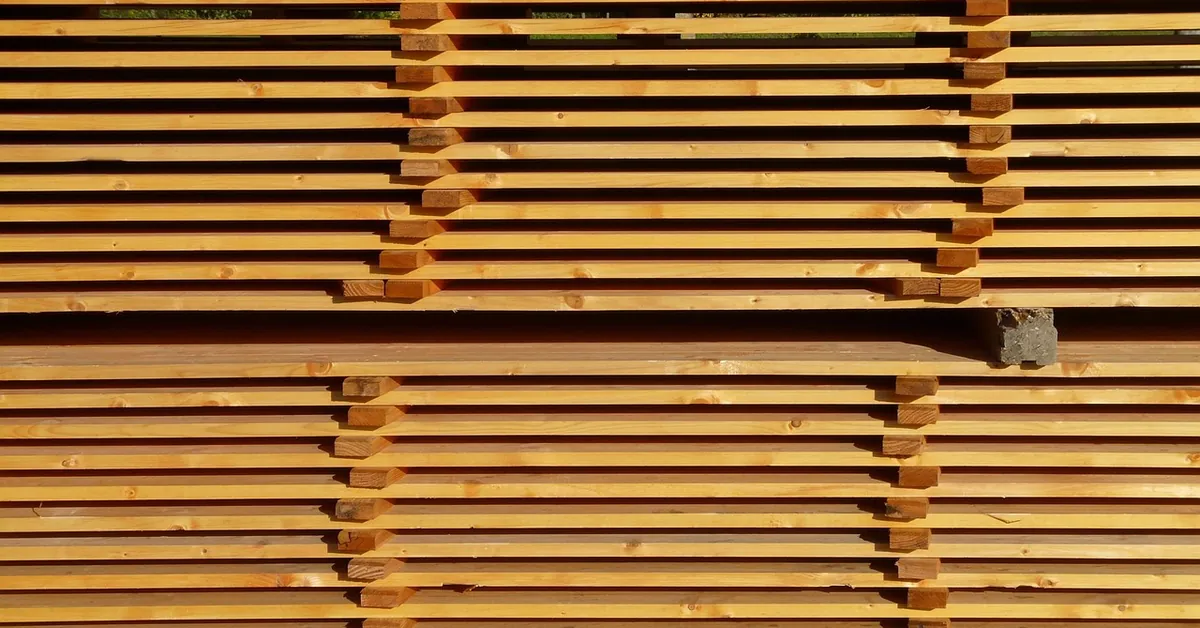 Stack of lumber boards separated by spacer sticks for air drying
