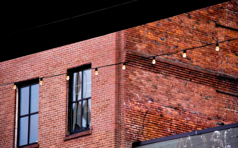 String lights hung across an exterior brick wall without drilling String lights hung across an exterior brick wall without drilling