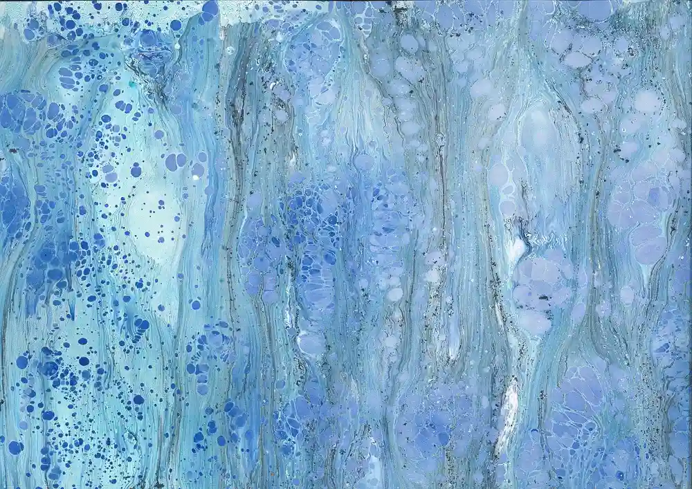 Blue and white marbled paper pattern created with water marbling paint