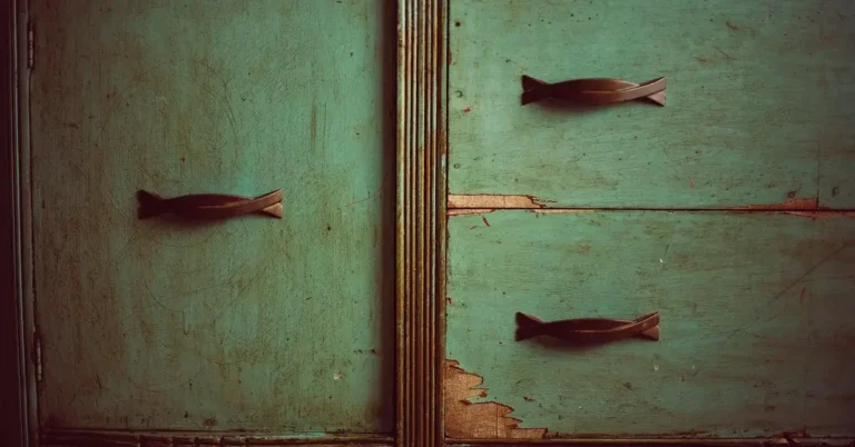 Green painted dresser with worn, distressed paint on the drawers and doors