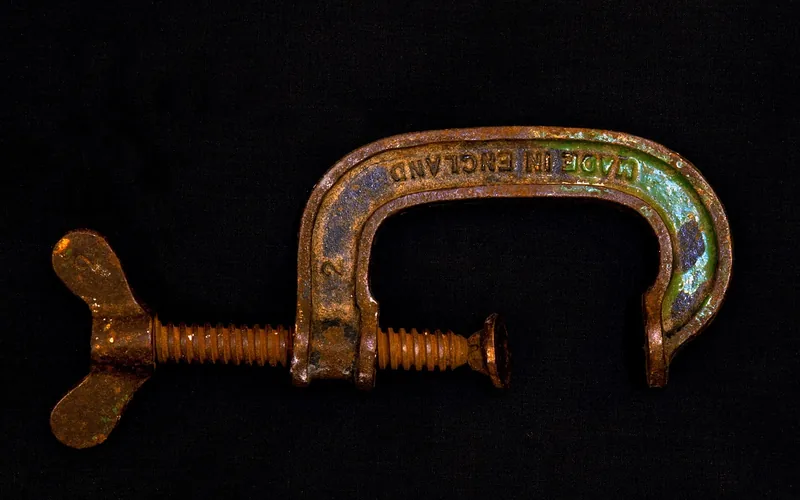 metal woodworking G-clamp used to hold a board flat while it dries