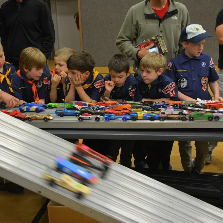 Pinewood Derby car racing down a wooden track