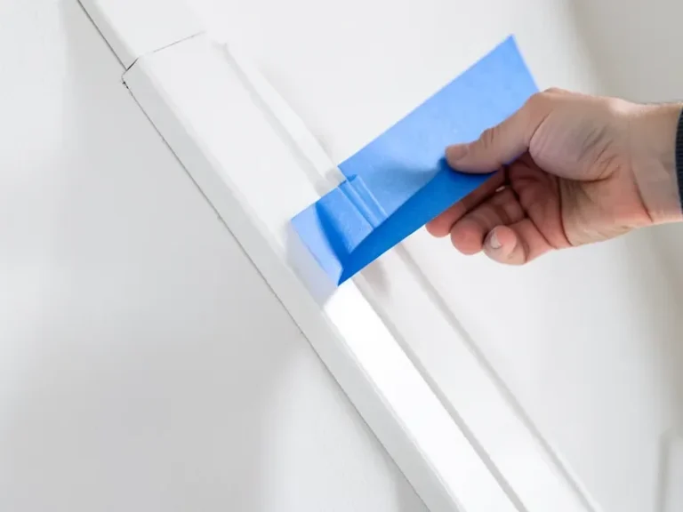 Pulling painter's tape at an angle off fresh trim paint for a crisp line