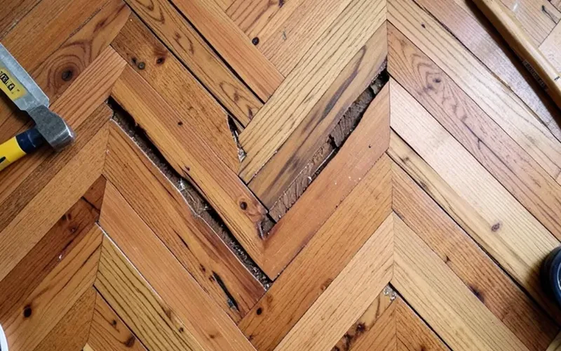 Removing a damaged plank from a herringbone hardwood floor for repair
