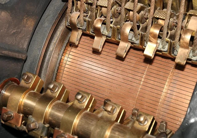 Close-up of a carbon brush and commutator assembly inside an electric motor, illustrating how brushed motors work