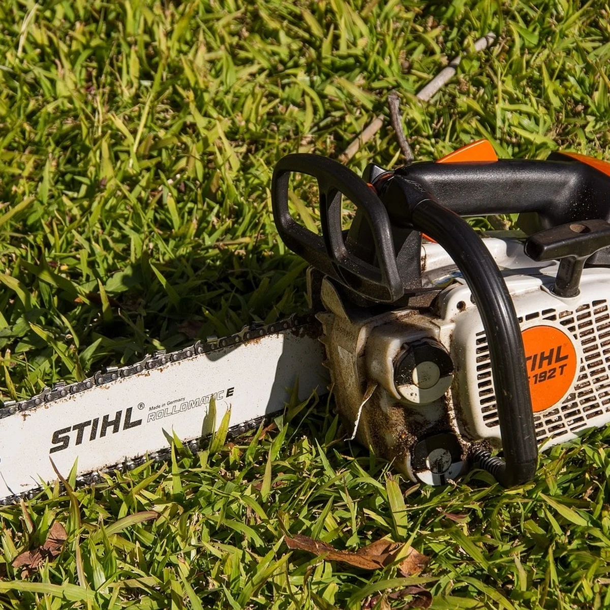 Real STIHL chainsaw resting in grass, representing the outdoor power equipment Stihl actually manufactures instead of reciprocating saws