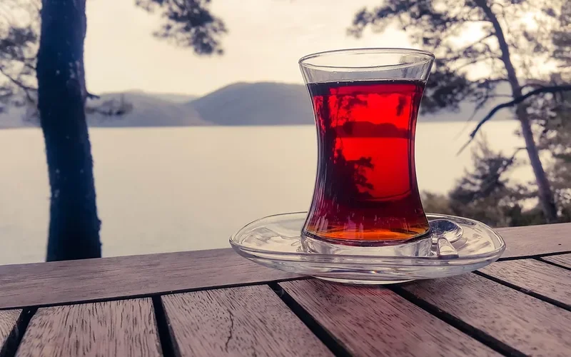 Tea glass sitting on a saucer on a wooden table to protect the finish Tea glass sitting on a saucer on a wooden table to protect the finish