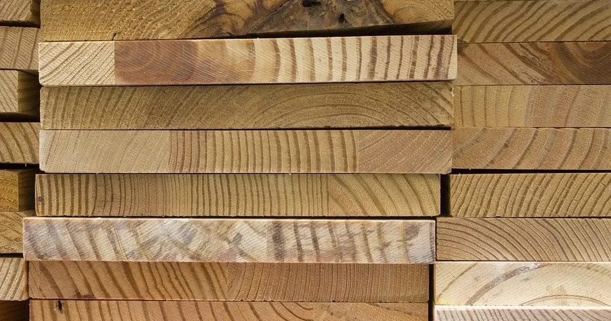 Stack of kiln-dried hardwood boards showing straight growth-ring patterns