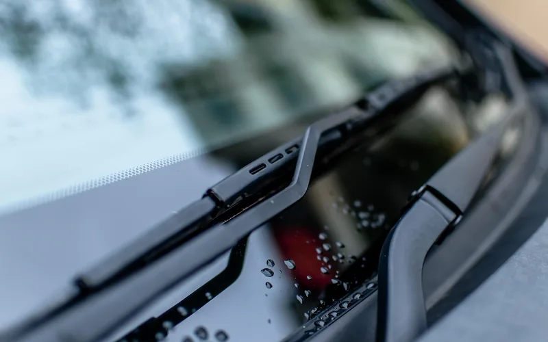 close-up of a car windshield being wiped clean of water spots