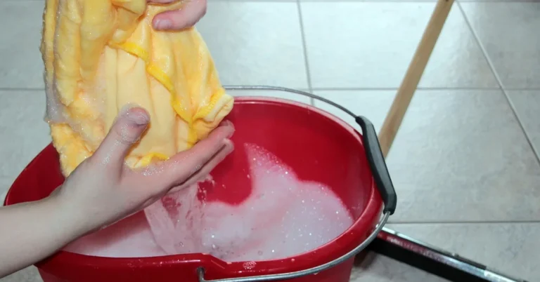 cleaning bucket with soapy water and scraper for removing concrete from painted surface