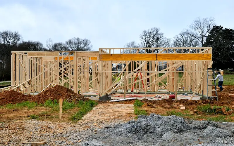 wood framed house under construction with the floor structure close to exposed ground