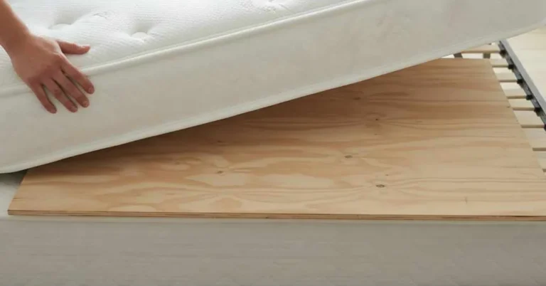 Plywood board placed under a mattress on a bed frame to add firmness