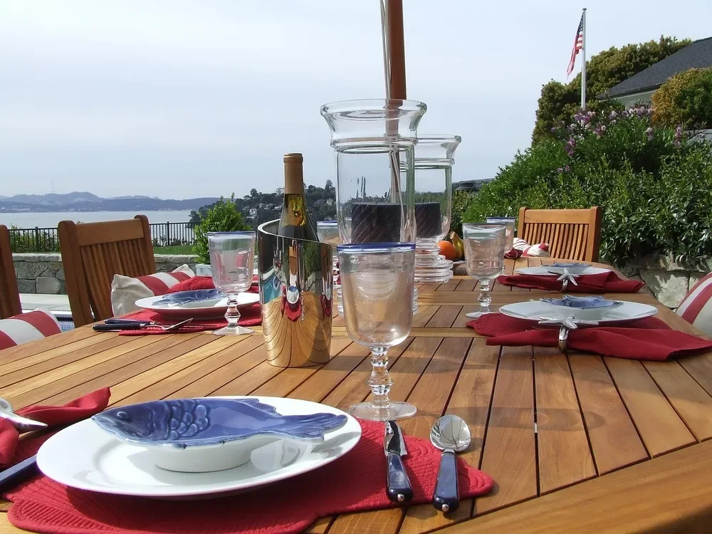 Golden-brown teak outdoor dining table set for a meal