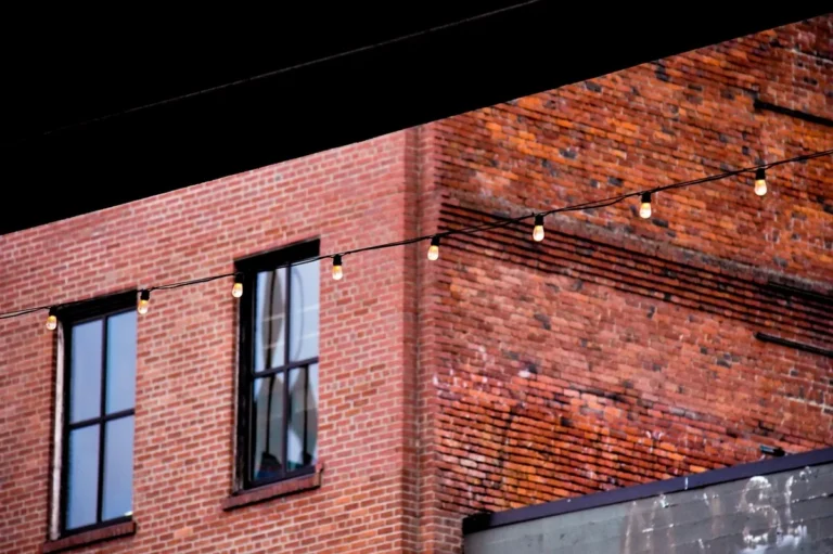 String lights hung on a brick wall using adhesive clips, no drilling