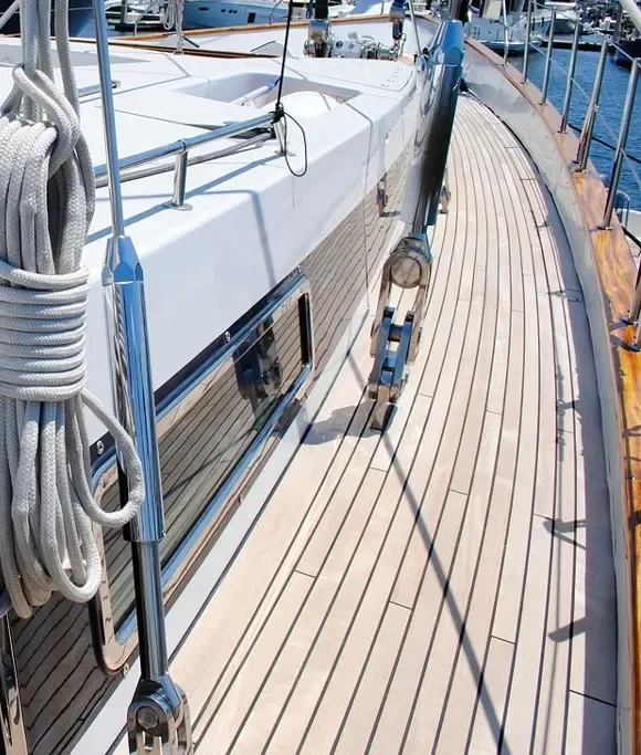 Teak planked yacht deck alongside a white hull