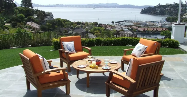 Wooden patio armchairs and round coffee table on a stone terrace
