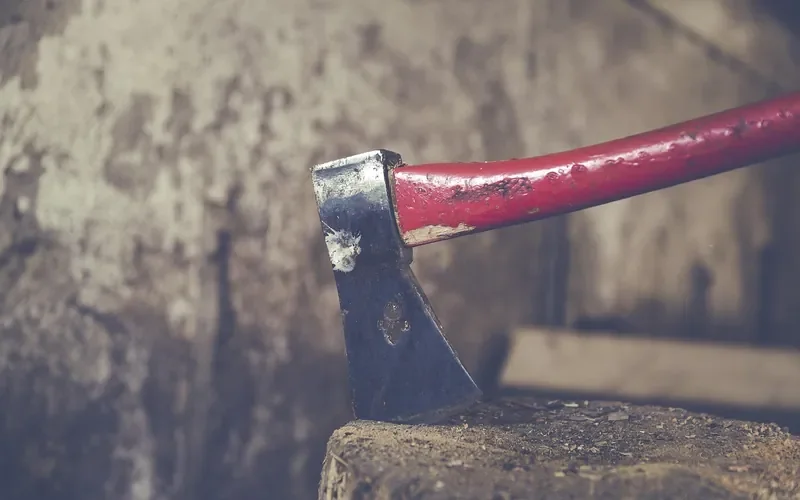 Wood-handled axe stuck in a chopping block Wood-handled axe stuck in a chopping block