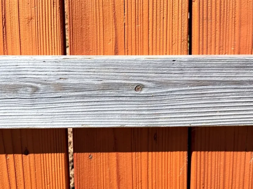Cedar fence board showing natural silvering next to its original reddish brown color