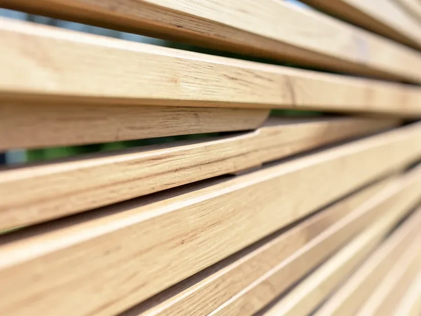 Close-up of a horizontal slat cedar fence showing the gap between boards