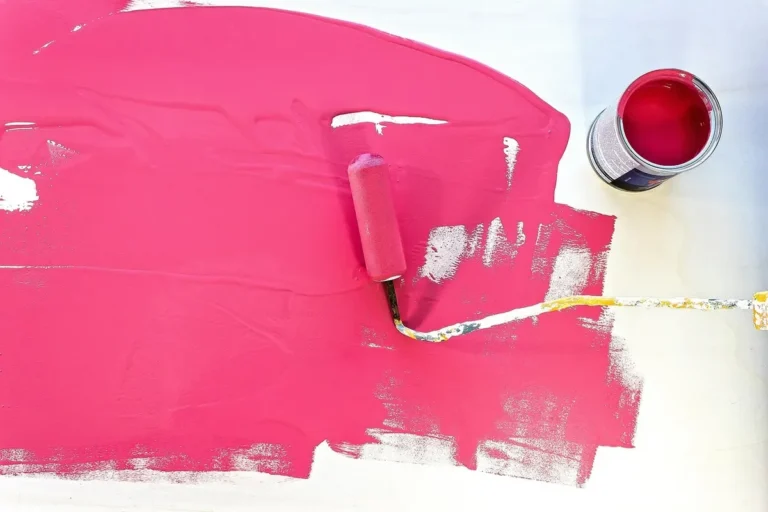 Roller applying a coat of paint across a flat wood panel