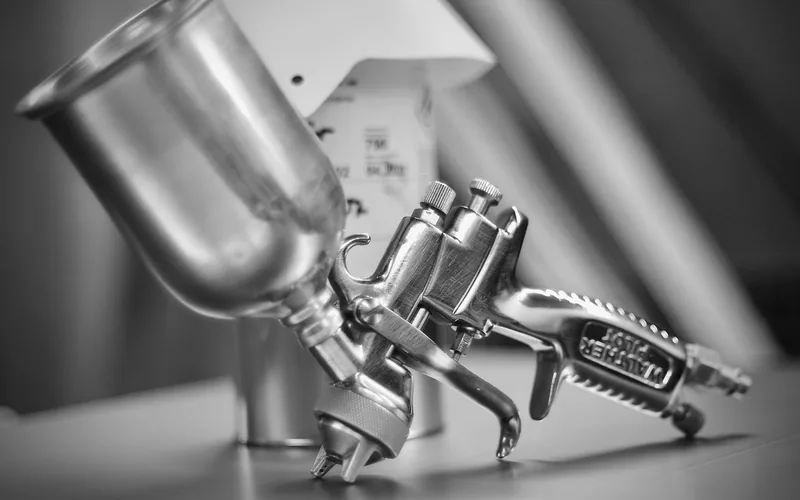 close-up of HVLP spray gun fluid adjustment knob and air cap