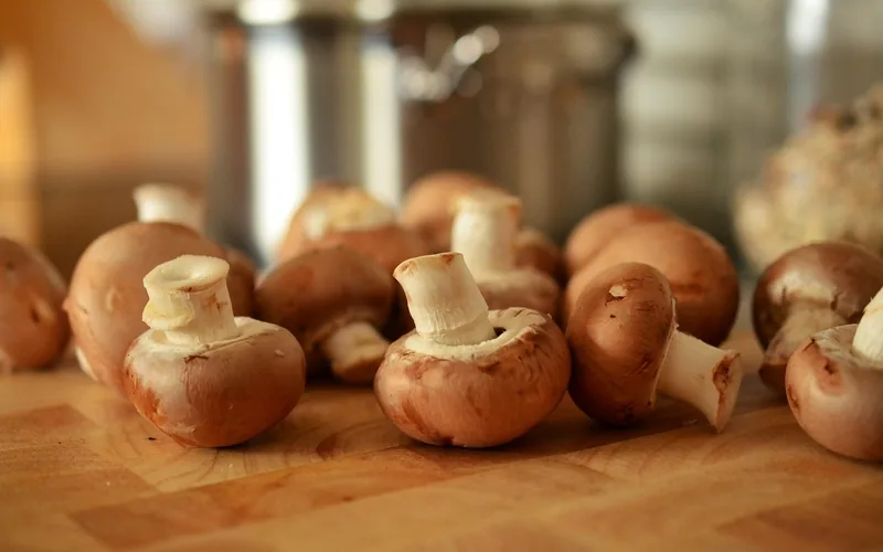 mushrooms on a wood cutting board in a kitchen ready for prep