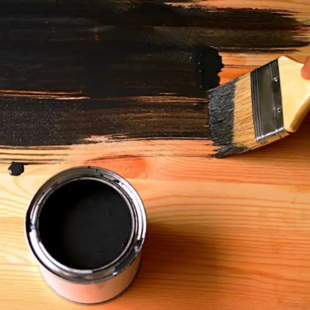 Brushing black stain onto raw wood