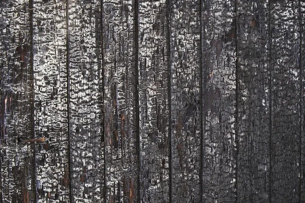 Close-up of charred boards showing the cracked, alligator-skin char surface