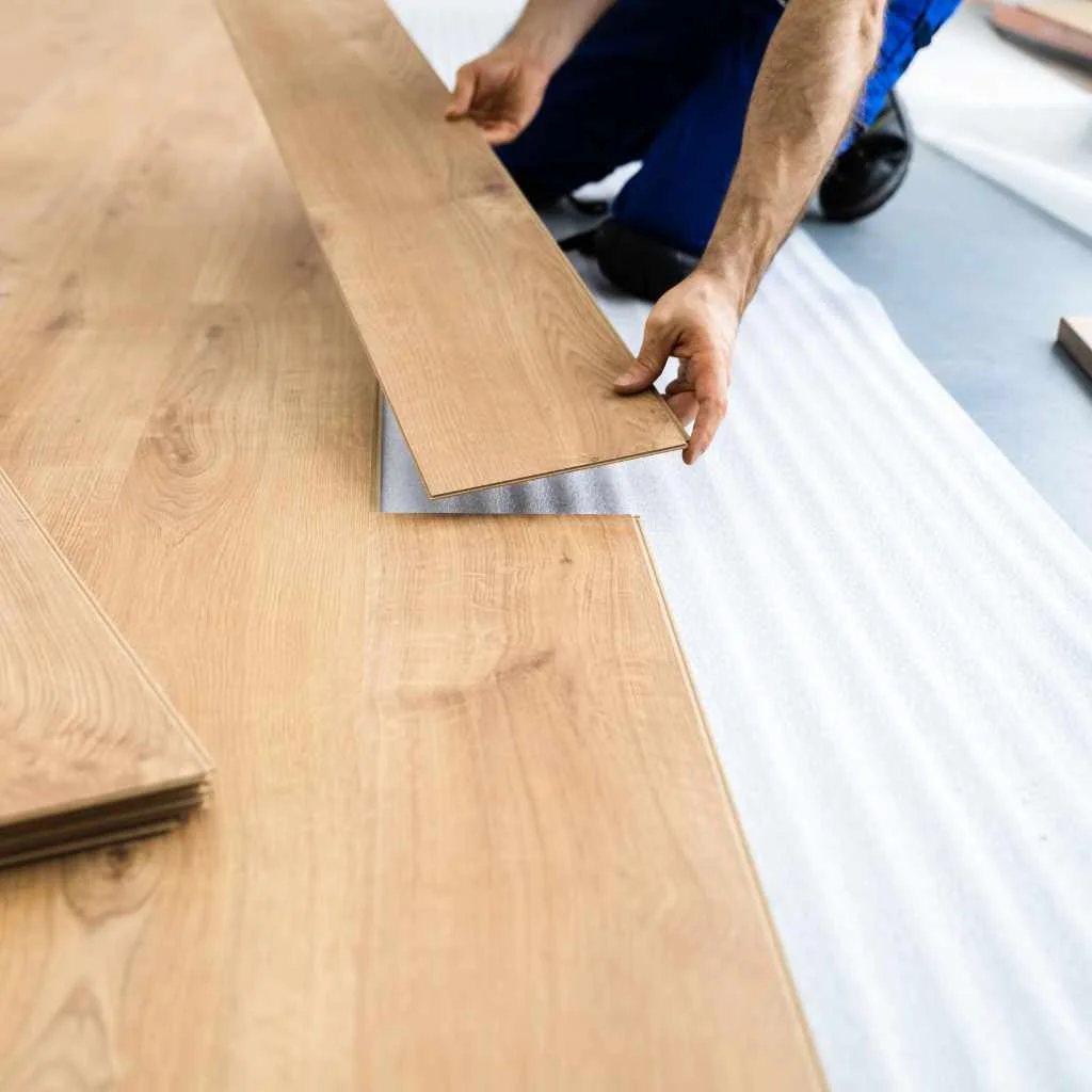 Foam underlayment being installed under a floating hardwood floor