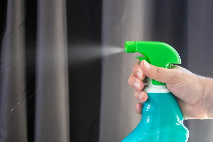 Hand spraying a ready-to-use spray cleaner from a trigger bottle